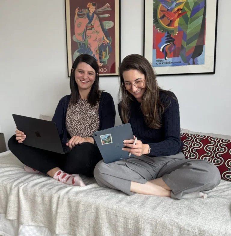Pauline et Marine, expertes en communication digitale chez Kommunique, travaillant ensemble sur ordinateur et tablette